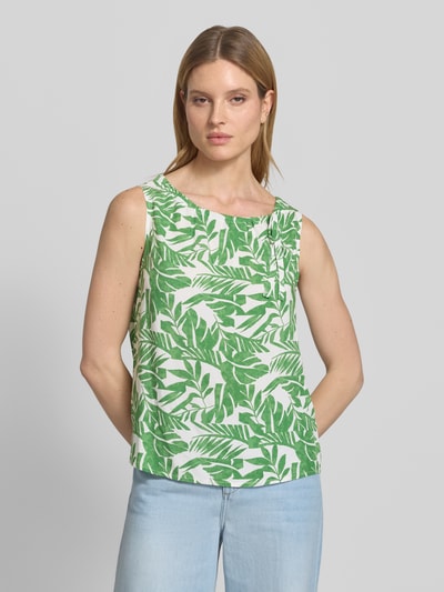 Frauenmodel trägt Blusenshirt mit Binde-Detail und Rundhalsausschnitt von More & More, grün-weißes Blattmuster, Reine Viskose, Gerader-Schnitt, Rückenlänge bei Größe 36: 57 cm, Ganzkörperansicht von vorne.