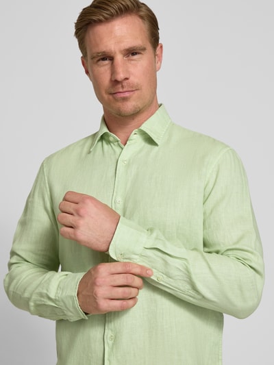 Männermodel trägt Leinenhemd mit Kentkragen von MCNEAL in Hellgrün, Reines Leinen, Regular-Fit, Knopfleiste, Nahaufnahme Oberkörper