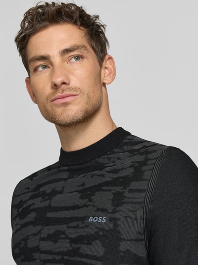 Męski model trägt Regular Fit T-Shirt aus Viskose-Mix Modell 'KN_Globe TS' von BOSS Green, imitacja dzianiny, napis z logo, okrągły dekolt, krótki rękaw, wykończenie materiału: mieszanka wiskozy, Nahaufnahme górnej części tułowia.