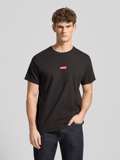 Männermodel trägt T-Shirt mit Label-Detail von Levi's®, schwarz, reine Baumwolle, relaxed Fit, Nahaufnahme Oberkörper.