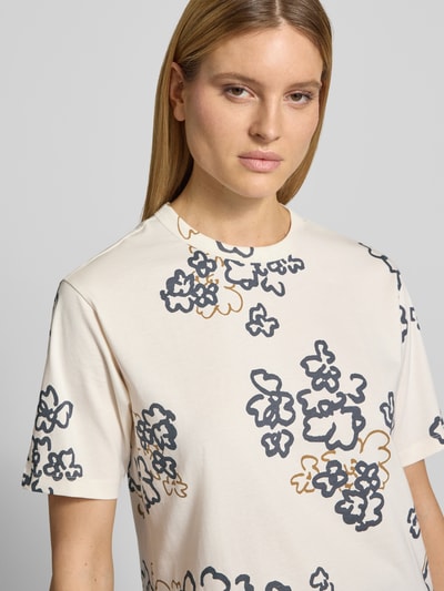 Modelka kobieca ma na sobie T-Shirt im Allover-Look mit Rundhalsausschnitt od JAKE*S STUDIO WOMAN, bawełna, krój relaxed fit, jasne kolory, kwiatowy wzór, widoczna tekstura materiału, widok z przodu, zbliżenie na górną część ciała.