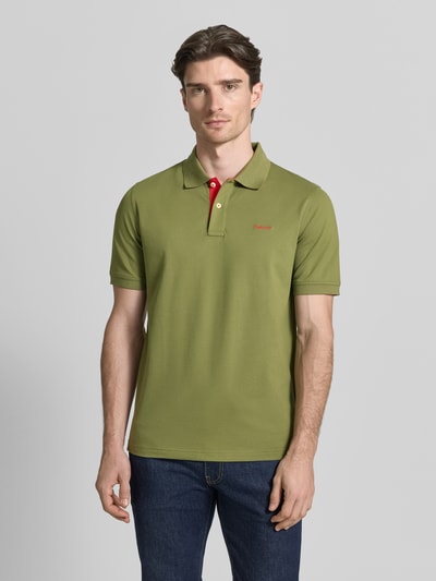 Männermodel trägt Regular Fit Poloshirt mit Logo-Stitching von Gant in Olivgrün, elastischer Baumwoll-Mix, Ganzkörperansicht von vorne.
