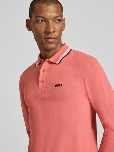 Männermodel trägt Regular fit poloshirt aus reine katoen model 'Plisy' van BOSS Green, zalmroze, zwarte kraagdetails, Nahaufnahme Oberkörper.