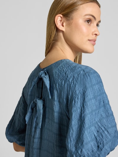 Frauenmodel trägt Minikleid aus Viskose-Mix mit Ballonärmel von Jake*s Casual in Blau, sichtbar Schlüsselloch-Ausschnitt hinten, Nahaufnahme Oberkörper schräg von hinten. Gerader Schnitt, strukturierte Oberfläche, weiche Textur.