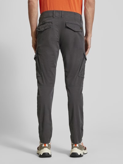 Mężczyzna model nosi Spodnie cargo z wyhaftowanym logo od PME Legend, mieszanka bawełny i elastanu, krój slim fit, kieszenie cargo, szerokość w rozmiarze 32/32: 44 cm, długość wewnętrzna nogawki: 77 cm, widok całej sylwetki z tyłu.