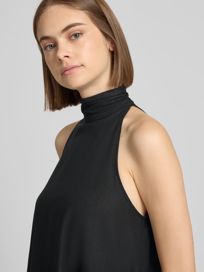 Frauenmodel trägt Minikleid aus Leinen-Mix mit Neckholder Modell 'SARA' von Topshop in Schwarz, glatte Textur, Nahaufnahme Oberkörper. Trapez Fit, Knopfverschluss, Schlüsselloch-Ausschnitt hinten, leichter Viskose-Anteil, Rückenlänge 85 cm, Brustweite 48 cm.