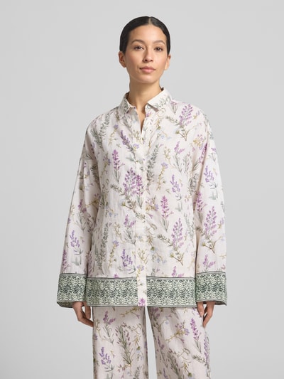 Frauenmodel trägt Florale Leinen Langarmbluse mit Lavendelprint von Christian Berg Woman, weiß mit lila Blumenmuster, Hemdblusenkragen, Relaxed Fit, Nahaufnahme Oberkörper.