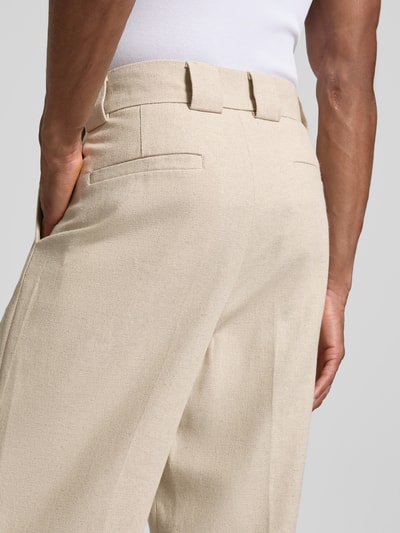 Męski model nosi Relaxed Fit Spodnie materiałowe z szlufkami na pasek od JAKE*S STUDIO MEN, detal z tyłu, zbliżenie na biodra. Szerokość w rozmiarze M: 45 cm, długość wewnętrzna nogawki: 77 cm.