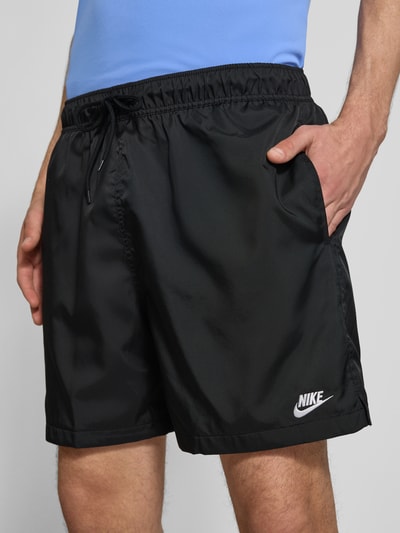 Männermodel trägt Shorts mit Label-Stitching und elastischem Bund von Nike, Regular-Fit in Schwarz mit Tunnelzug, Nahaufnahme Oberkörper. Kontext: Herren Shorts mit Bundweite 41 cm und Innenbeinlänge 14 cm bei Größe M.