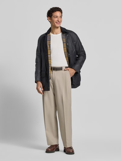 Männermodel trägt Taillierte Funktionsjacke aus gewachster Baumwolle Modell 'BRISTOL' von Barbour, dunkle gewachste Oberfläche, aufgesetzte Außentaschen und Cordkragen, klassisch-funktionales Design, Komplettfutter sichtbar, Ganzkörperansicht von vorne.