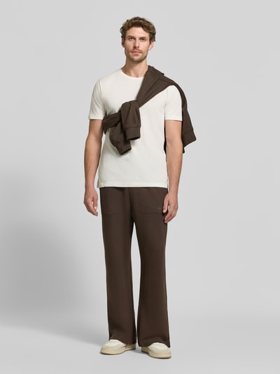 Männermodel trägt Regular Fit Sweathose aus Baumwoll-Modal-Mix von Tommy Hilfiger in Dunkelbraun, lockerer Schnitt, Ganzkörperansicht von vorne. Herren Sweathose von Tommy Hilfiger.