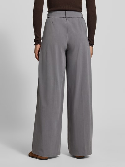 Frauenmodel trägt Wide Fit Hose mit Viskose-Anteil von MYON in Grau, elastischer Material-Mix, Bundfalten, Ganzkörperansicht Rückansicht.