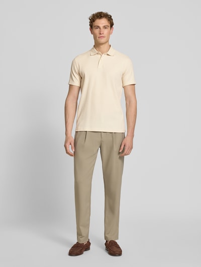 Männermodel trägt Regular Fit Poloshirt aus Baumwoll-Mix Modell 'BLAZE' von SELECTED HOMME, unifarben, kurze Knopfleiste, Ganzkörperansicht von vorne.