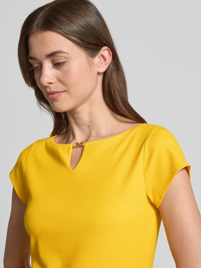 Modelka kobieca nosi T-Shirt mit Cut Out od Marc Cain, żółty modal-mix z dodatkiem stretchu, prosty krój, drobny prążek, okrągły dekolt, cut out, długość tyłu w rozmiarze 36: 56 cm, zbliżenie na górną część ciała
