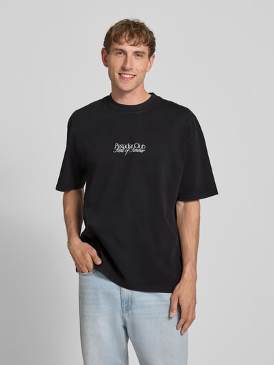 Mannelijk model draagt oversized T-shirt met labelprint model 'Ramon' van PEGADOR, puur katoen, ronde hals, ruglengte maat M 70 cm, vooraanzicht bovenlichaam