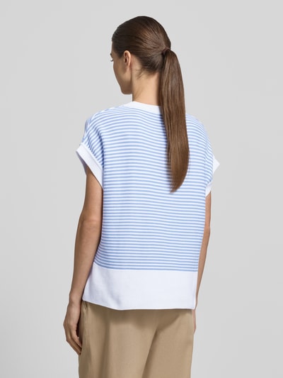 Frauenmodel trägt T-Shirt aus reiner Baumwolle in Strick-Optik Modell 'Kipe' von JOOP! mit hellblau-weißen Streifen, lockere Passform, Ganzkörperansicht Rückansicht.