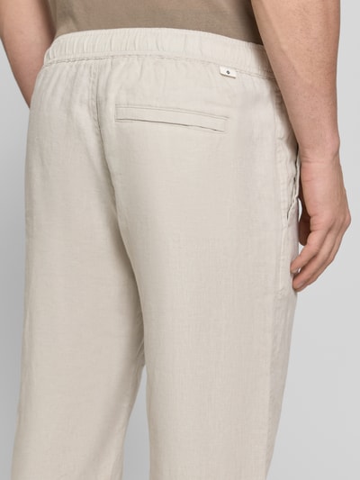 Männermodel trägt Leinenhose mit Eingrifftaschen Modell 'JABARI' von Samsøe Samsøe, reines Leinen, Relaxed-Fit, Gesäßleistentasche, Nahaufnahme Rückansicht.