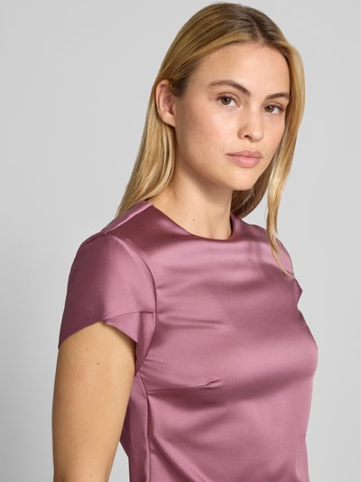 Frauenmodel trägt Bluse aus Satin von Rinascimento in Rosa mit Rundhalsausschnitt, Material-Mix, Kurzarm, Nahaufnahme Oberkörper.