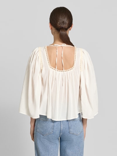 Frauenmodel trägt Cropped Bluse mit 3/4-Arm Modell 'ISMARA' von Drykorn aus Baumwoll-Viskose-Mix in Creme, Rückenlänge 35 cm, Ganzkörperansicht Rückansicht.