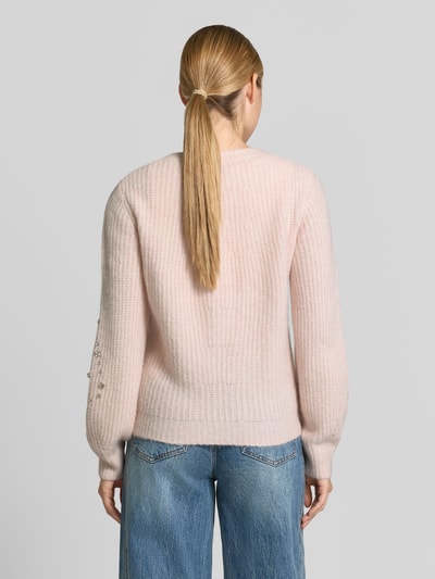 Vrouwenmodel draagt Regular Fit Cardigan met Ziersteinbesatz van monari in tricotlook, getailleerd, lichtroze tint, ruglengte 60 cm, mouwlengte 71 cm, tweewegritssluiting, ronde hals, rugaanzicht.