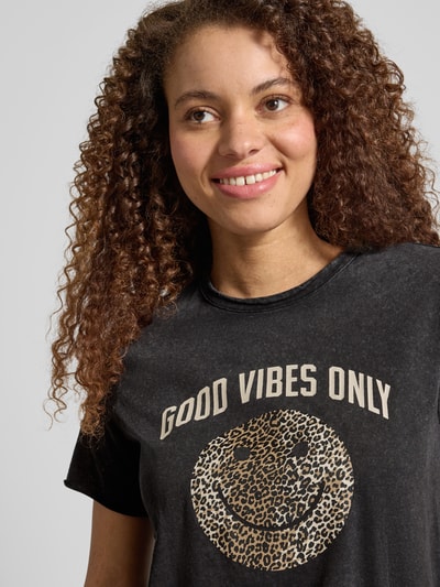 Frauenmodel trägt Regular Fit T-Shirt aus reiner Baumwolle Modell 'LISA LIFE LUCY' von Only, unifarben, Motiv-Print, Nahaufnahme Oberkörper.