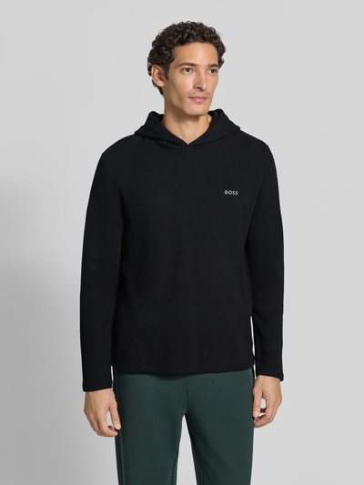 Männermodel trägt schwarzen Relaxed Fit Sweatshirt aus Baumwoll-Mix Modell 'Waffle LS' von BOSS, Ganzkörperansicht von vorne, Herren Hoodie.