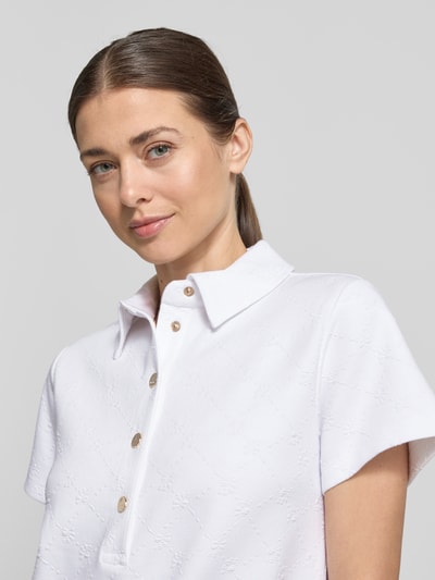 Frauenmodel trägt Regular Fit Kleid mit Polo-Kragen Modell 'Torrin' von JOOP! aus Baumwoll-Mix, kurzärmelig, strukturierte Oberfläche, Nahaufnahme Oberkörper.