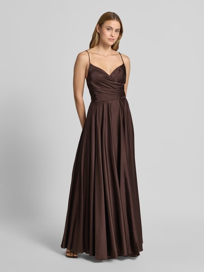 Frauenmodel trägt Maxikleid mit rückseitiger Schnürung von Hey Kyla aus Material-Mix mit Stretch-Anteil in A-Linie, V-Ausschnitt, glatter brauner Stoff, glänzende Textur, Rückenlänge bei Größe 36: 126 cm, Brustweite: 38 cm, Ganzkörperansicht von vorne.