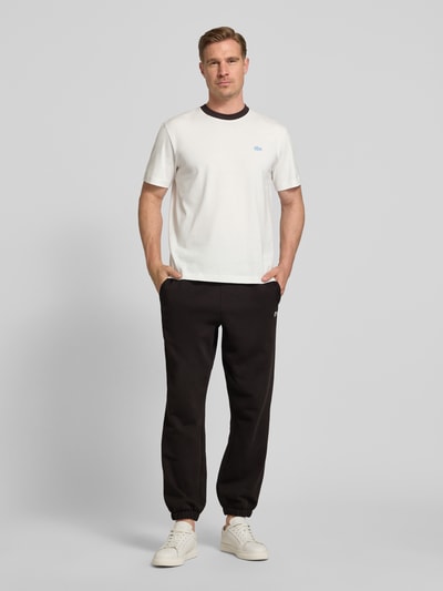 Męski model nosi Regular Fit Sweatpants aus Baumwoll-Mix von Lacoste, efekt: jednolity kolor, wyhaftowane logo, krój regular fit, tunel wewnętrzny, ściągacz, elastyczne zakończenie nogawek, wpuszczane kieszenie, wykończenie materiału: dzianina dresowa, szczotkowany polar, mieszanka bawełny; Ganzkörperansicht von vorne