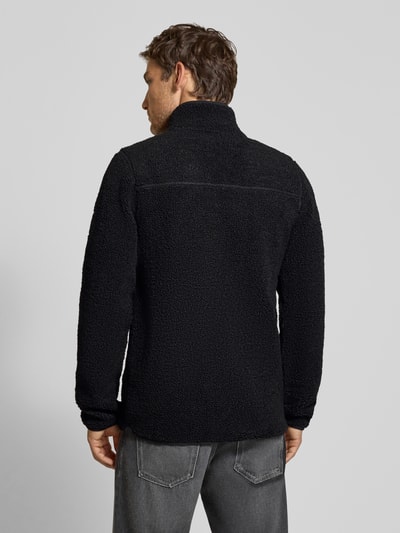 Männermodel trägt Regular Fit Jacke mit Stehkragen Modell 'Peter' von Didriksons, schwarzes Strukturmuster, Ganzkörperansicht Rückansicht.
