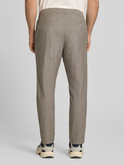Männermodel trägt Tapered Leinenhose aus Baumwoll-Leinen-Mix Modell 'LINUS' von Only & Sons in Melange-Optik, Ganzkörperansicht Rückansicht.