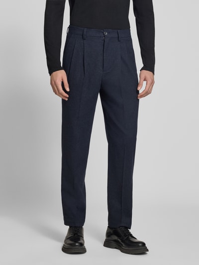 Męski model nosi Straight Fit Stoffhose mit Baumwoll-Anteil od Lindbergh, elastyczna mieszanka materiałów z bawełną, kolor granatowy, zapięcie na guzik i zamek błyskawiczny, wpuszczane i tylne kieszenie, kontrafałdy, szerokość w rozmiarze M: 41 cm, długość wewnętrzna nogawki: 80 cm, widok całej sylwetki z przodu.