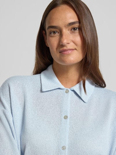 Frauenmodel trägt hellblaues Strickshirt aus Viskose-Mix mit Polokragen und Knopfleiste Modell 'Sitrica' von OPUS, Relaxed-Fit, Nahaufnahme Oberkörper. Rückenlänge bei Größe 36: 54 cm.