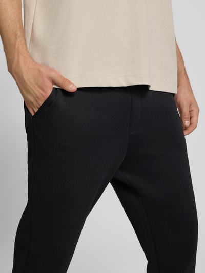 Männermodel trägt zwarte Regular fit sweatpants met steekzakken Model 'GORDON' van JACK & JONES, Materiaalmix met katoen, Nahaufnahme heupen