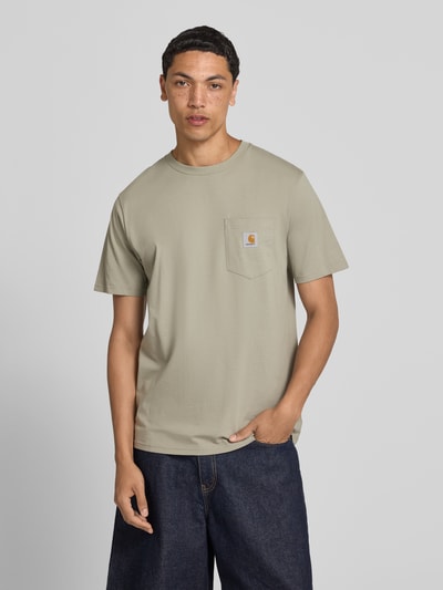 Männermodel trägt Regular Fit T-Shirt mit Brusttasche von Carhartt Work In Progress, Herren T-Shirt aus Reine Baumwolle, Rundhalsausschnitt, Label-Patch, Rückenlänge 71 cm bei Größe M, Ganzkörperansicht von vorne.