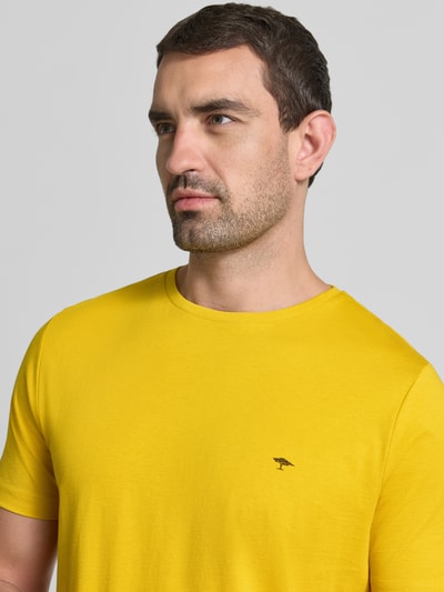 Männermodel trägt T-Shirt mit Rundhalsausschnitt und Label-Stitching von Fynch-Hatton, reine Baumwolle, Regular Fit, Nahaufnahme Oberkörper.