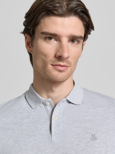 Męski model nosi Koszulkę polo z drobno strukturalną fakturą od MARC O’POLO, bawełna, prosty krój, jednokolorowa, haftowane logo, zbliżenie na górną część ciała.
