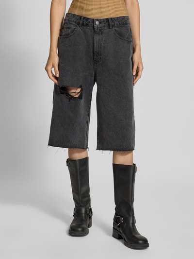 Frauenmodel trägt Jeansshorts im Destroyed-Look von Karo Kauer in Schwarz mit Cut Out, Eingrifftaschen, lockere Passform, Nahaufnahme Oberkörper. Damen Jeansshorts von Karo Kauer, Relaxed Fit, Bundweite bei Größe S: 41 cm, Innenbeinlänge bei Größe S: 37 cm.