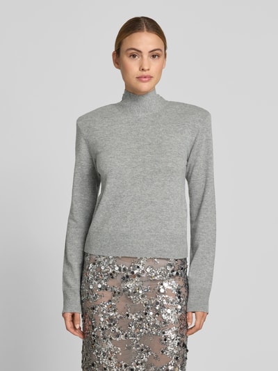 Frauenmodel trägt Regular Fit Pullover aus Woll-Mix von ROTATE, Strick-Optik, Rollkragen, Schulterpolster, grau, Ganzkörperansicht von vorne. Rückenlänge bei Größe S: 50 cm, Kaschmir-Anteil, Damen Pullover.