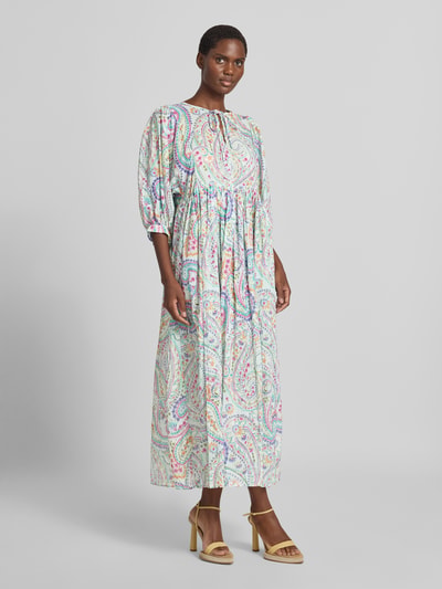 Frauenmodel trägt Midikleid aus reiner Baumwolle mit Allover-Paisley-Print von Milano Italy in Pastellfarben, Relaxed Fit, Ganzkörperansicht von vorne.