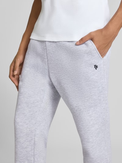 Mężczyznamodel nosi jasnoszare Slim Fit Sweatpants mit Tunnelzug von REVIEW, krój slim fit, wpuszczane kieszenie, kieszeń z tyłu, długość wewnętrzna nogawki w rozmiarze M: 80 cm, zbliżenie na górną część nogawek z boku.