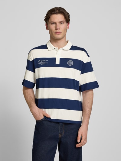Männermodel trägt Relaxed Fit Poloshirt aus reiner Baumwolle Modell 'DEVIN' von Only & Sons, gestreift, kurzarm, Jersey, Ganzkörperansicht von vorne.