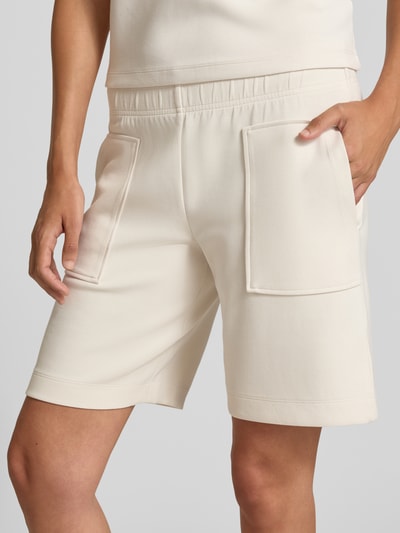 Vrouwenmodel draagt Regular Fit Shorts met elastische band van Christian Berg Woman, elastische materiaalmix, siernaden, detailopname voorzijde.