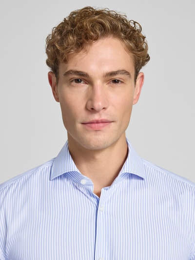 Mannelijk model draagt lichtblauw-wit gestreept slim fit zakelijk overhemd uit katoen model 'HANK' van BOSS, close-up bovenlichaam.