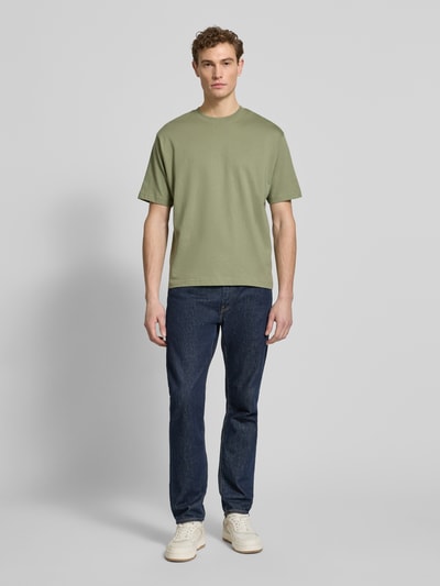 Männermodel trägt Regular Fit T-Shirt aus reiner Baumwolle von MCNEAL in Olivgrün, kurzärmelig, Rundhalsausschnitt, Ganzkörperansicht von vorne.