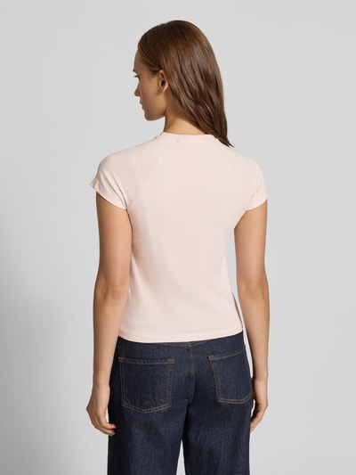 Frauenmodel trägt T-Shirt mit Raglanärmeln Modell 'KATINKA' von NOISY MAY®, hellrosa Ton, glatte Baumwoll-Elasthan-Oberfläche, eng anliegend, Ganzkörperansicht Rückansicht.