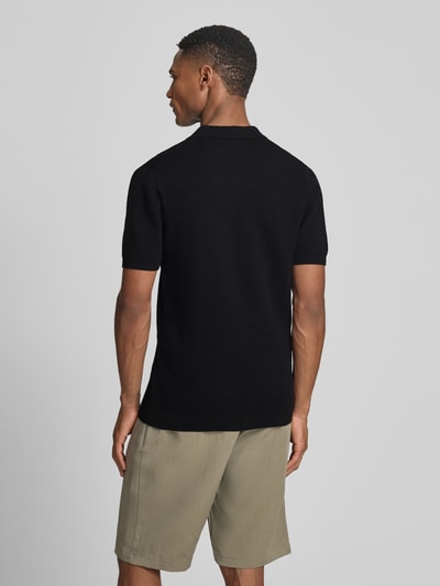 Männermodel trägt Slim Fit Poloshirt Modell 'Triton' von Drykorn aus reiner Baumwolle mit Polokragen, Strukturmuster, Rückenlänge 67 cm, Ganzkörperansicht Rückansicht.