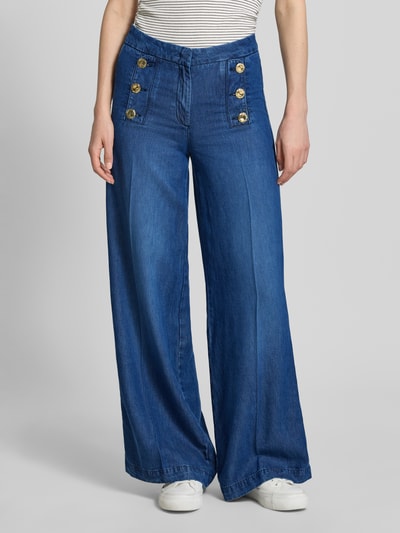 Frauenmodel trägt Wide Leg Jeans mit Zierknöpfen und französischen Eingrifftaschen von Rich & Royal, Baumwoll-Mix, ausgestellter Schnitt, Haken-Reißverschluss, Bügelfalte, Seitliche Zierknöpfe, Bundweite 38 cm, Innenbeinlänge 18 cm, Ganzkörperansicht von vorne.