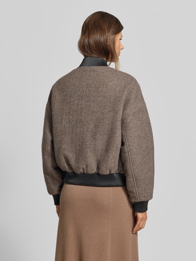 Frauenmodel trägt Bomberjacke mit Baumwoll-Viskose-Anteil von MYON in Braun mit elastischen Abschlüssen und Stehkragen, Rückenansicht. Regular Fit, Materialmix, Reißverschluss, Kombi mit Rock.