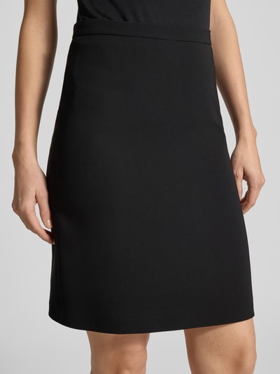 Frauenmodel trägt Ausgestellter knielanger Rock mit Reißverschluss Modell 'TONDATA' von Max Mara Studio in Schwarz, Webware, Nahaufnahme Oberkörper.